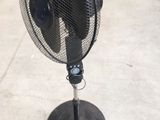 a black fan sitting on top of a metal stand