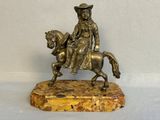 statue en bronze représentant un homme à cheval, posée sur un socle en marbre