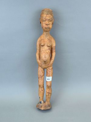un gros plan sur une statue en bois représentant une personne, sur laquelle est accrochée une étiquette