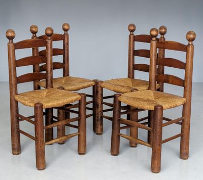 three wooden chairs with canes on them sit in a row
