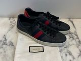 a pair of black and red sneakers on a marble surface