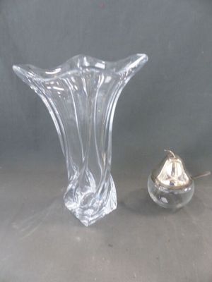 un vase en verre et un petit objet en argent posés sur une table