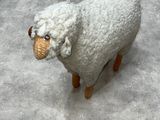a stuffed sheep that is sitting on the floor