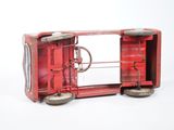 a red toy train car with wheels on a white surface