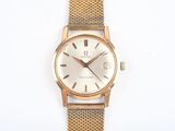 an image of a gold wrist watch on a white surface