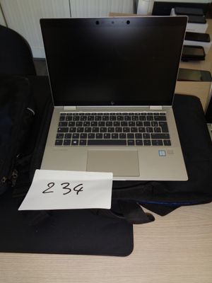 a laptop computer sitting on top of a desk next to a bag