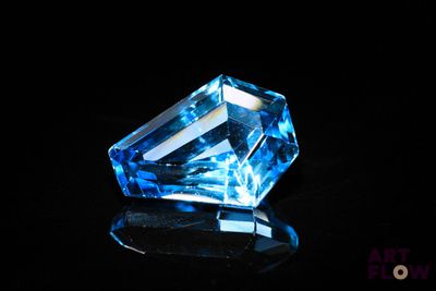 a close up of a blue diamond sitting on top of a black surface