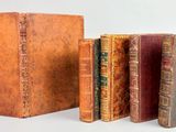 plusieurs vieux livres sont alignés sur une surface blanche