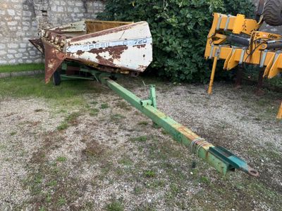 un petit bateau posé sur une remorque dans la cour
