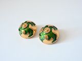 pair of green and gold earrings on a white surface