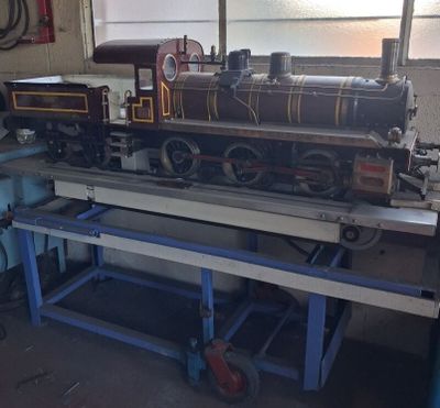 a model train sitting on a workbench in a garage