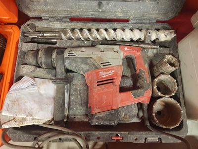une boîte à outils contenant des outils tels qu'une perceuse, des marteaux et d'autres outils