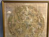 une vieille carte du monde dans un cadre doré accrochée à un mur blanc