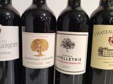 several bottles of red wine are lined up on a table