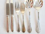 cinq fourchettes, un couteau, une cuillère et un couteau sur une table