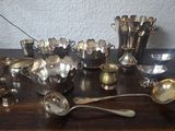 beaucoup de cuillères et de tasses en argent sur une table