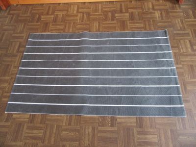 un tapis rayé noir et blanc posé sur un parquet