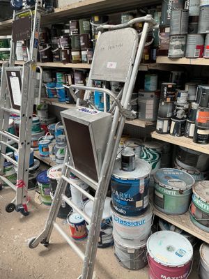 many cans of paint on the shelves in the store