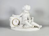 une petite statue représentant un garçon assis sur une horloge