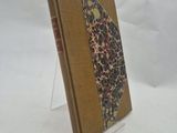 un vieux livre posé sur une table blanche, devant un fond blanc