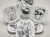 six assiettes à motifs différents posées sur une surface blanche
