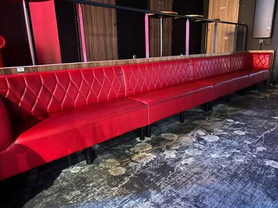 a long red bench in the middle of a room