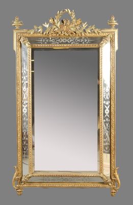 un miroir richement décoré, avec un cadre doré sur fond gris