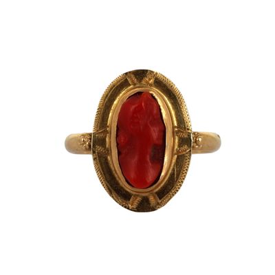 une bague en or avec une pierre rouge au centre