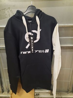 un sweat à capuche suspendu à un cintre dans un magasin de vêtements, avec un sweat à capuche blanc et noir