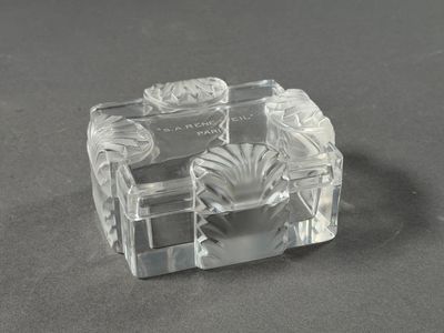 a clear glass candle holder on a black surface