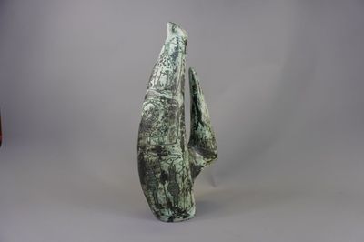 sculpture représentant un homme debout devant un fond gris