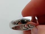 a person holding a silver ring in their hand