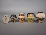 five different vases that are sitting on a table