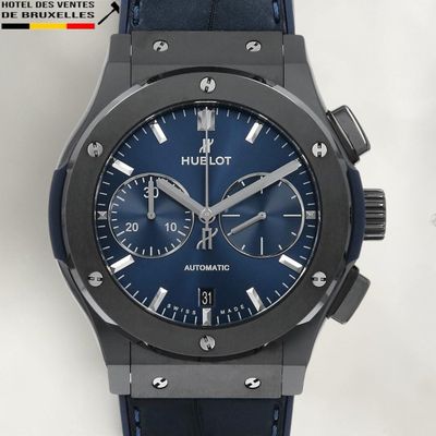 La montre possède un cadran bleu et un bracelet en cuir noir.