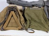 many different types of bags and backpacks sitting on a table