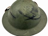 an old green helmet with a brown leather strap on a white background