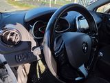 steering wheel and dashboard of a car on a road with a stop sign in the background