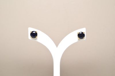 pair of black and white diamond stud earrings on a white stand