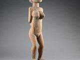 une statue en bois d'une femme avec un chapeau sur la tête