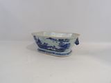 a blue and white bowl with a handle on a table