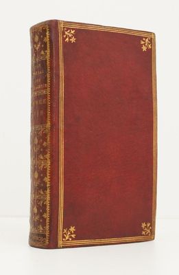 un vieux livre à la couverture rouge et à la bordure dorée