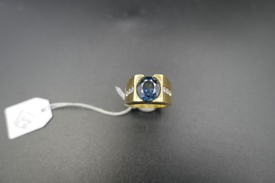 Gros plan sur une bague en or ornée d'une topaze bleue