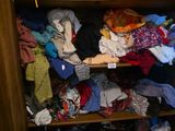 une armoire remplie de vêtements et de chaussures dans une armoire