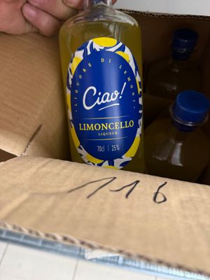 une personne en train d'ouvrir une boîte en carton contenant une bouteille de limonade