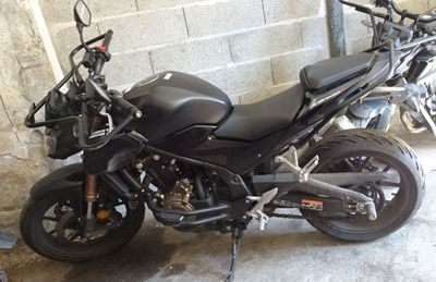 une moto noire garée dans un garage, près d'un mur de briques