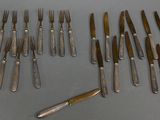 un assortiment de couverts comprenant un couteau, une fourchette et un repose-couteau