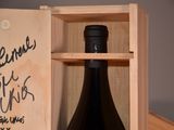 a wooden box with a bottle of wine inside of it