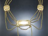 gros plan d'un collier en or sur une surface noire