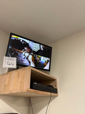 a television that is on top of a shelf in a room