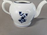 a white tea pot with blue flowers on it